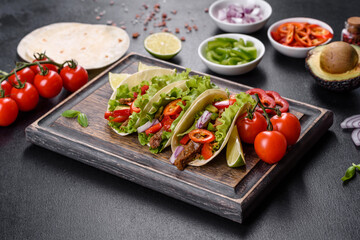 Mexican tacos with beef, tomatoes, avocado, onion and salsa sauce