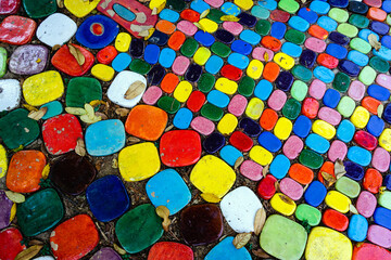Top view on pieces of multicolored ceramic tiles decorated in garden. Old pavement of tiles textured. Street mosaic cobblestone sidewalk. Abstract,background and pattern of ceramic tile on the floor.