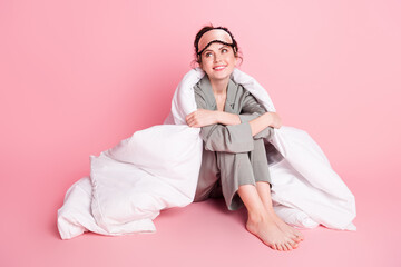 Full length body size photo of girl in sleeping wear mask sitting dreamy in blanket smiling looking copyspace isolated on pastel pink color background