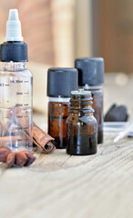 bottles of essential oil with spice, stick of cinnamon and star of anise