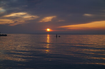 Naklejka premium Dawn over the Black Sea and a man on a kayak who meets him.