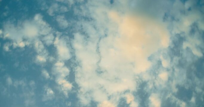 Fast camera rotation on its axis looking to the cloudy blue sky on the evening with sunset