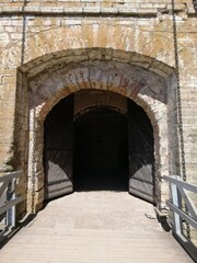 the entrance to the stone castle with a big gate is through a swing bridge on chains. Ancient fortress