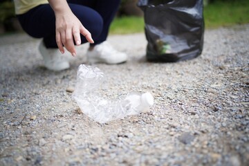 Volunteer charity woman hand holding garbage black bag and plastic bottle garbage for recycling for cleaning at park volunteering concept reuse and volunteer helping