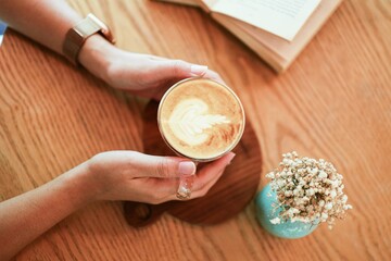 Woman hands  holding cup of coffee with latte art. holding cup of tea or coffee in the morning