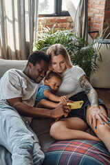 Fototapeta premium Multi ethnic family of couple and their daughter on bed