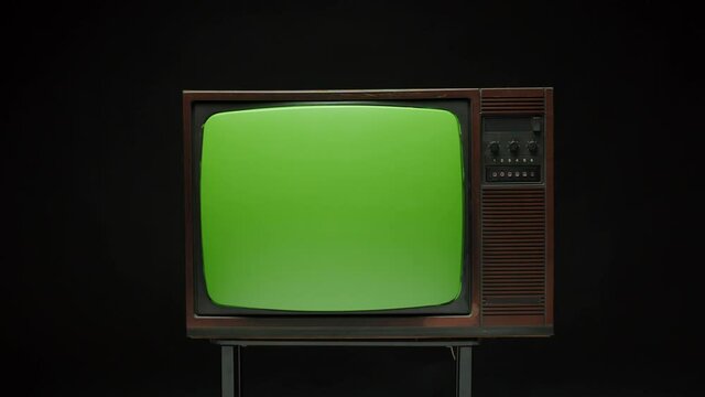 Old retro television with antenna on grey background. Broken old-fashioned TV screen with ripples on table, bad signal reception, cinematography concept.