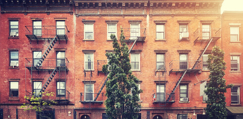 Old red brick buildings with iron fire escapes, color toning applied, New York City, US.