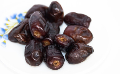 A bunch of dried black dates fruit in a plate