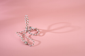 Rope and knot on pink background