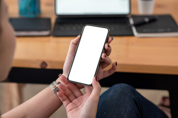 Close-up of businesswoman holding smartphone in smartphone in office with blank white screen.