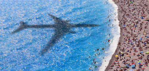 Fototapeta na wymiar Waves on the beach with shadow of commercial airplane flying above beautiful tropical beach