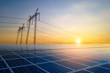 High voltage pylons with electric power lines transfering electricity from solar photovoltaic sells...
