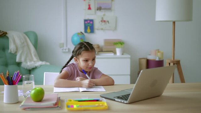 Home education of children girl writes in copybook at lesson Spbd