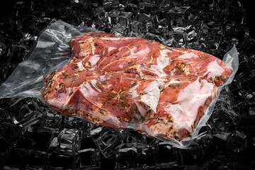 Vacuum-packed meat, on dark ice background, pork steak. Semifinished.