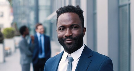 Fototapeta premium Portrait view of the confident multiracial man wearing formal clothes achieving business success and standing while smiling to the camera