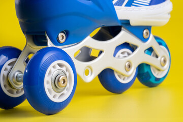 Fototapeta premium Blue skates shoes on yellow background