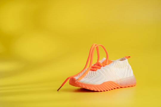 An orange children's sports shoes on a yellow background