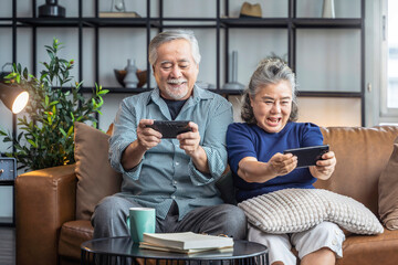 happiness asian retired couple enjoy playing and competition game smartphone mobile online together...
