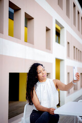 young latin woman on terrace with her white smartphone