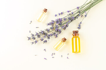 Bottles of lavender essential oil or perfume with flowers top view