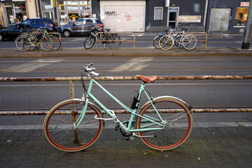 Fahrrad am rostigen Geländer einer Straßenbahnhaltestelle im Sommer im Stadtteil Sachsenhausen in...