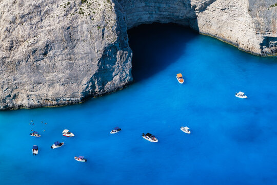 A boats in the lagoon near Navagio Beach, Zakynthos Island, Greece. View of the sea bay and a boats from a drone. Blue sea water. Vacation and travel. Summer landscape from the air.