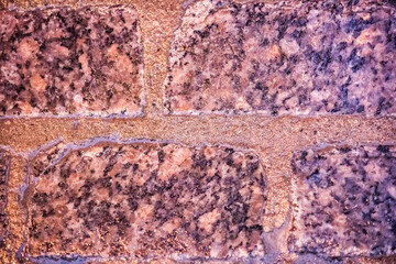 Macro closeup of colorful, vibrant and cobblestone street at night after rain with reflection of lights