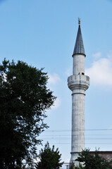 Beautiful minaret against the blue sky. Clear summer, sunny day in the city.