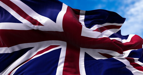 Fototapeta premium The national flag of the United Kingdom flying in the wind. Outdoors and sky in the background.