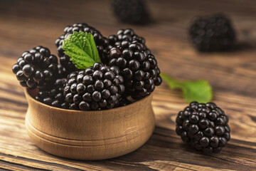 Mulberries on the table in a wooden bowl