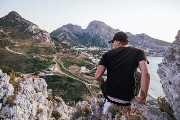 Un hombre excursionista mirando el atardecer junto a la frontera de Benzú