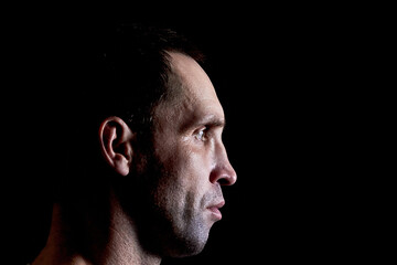 Serious mature man shirt in profile on a dark background