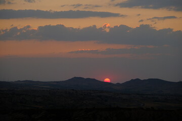 Sunset point in Urgup, Goreme with just before sun goes away in rose valley sunset (kizilvadi) and dramatic sky and clouds.