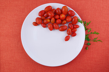 Fototapeta na wymiar cherry tomatoes on white plate in top view.