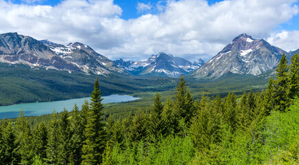 Spring at Two Medicine Valley - A panoramic overview of Lower Two Medicine Lake surrounded by rugged high mountain peaks on a sunny Spring morning in Glacier National Park, Montana, USA.