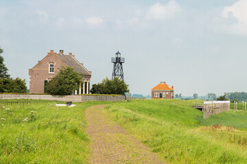 Fototapeta na wymiar Lightkeepers House, lighthouse and a small foghorn house on the former island of Schokland in the Zuiderzee