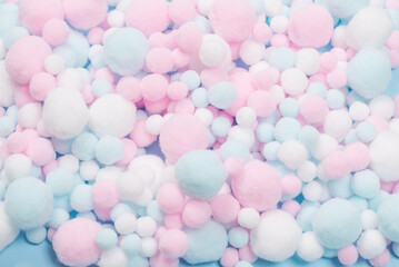 White, pink and blue soft pompons as a background.