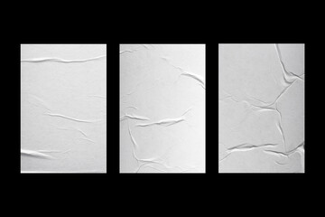 Three sheets of white paper with folds isolated on a black background.