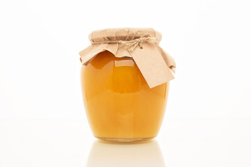 A glass jar full of sweet honey with a place for your text, isolated on a white background.