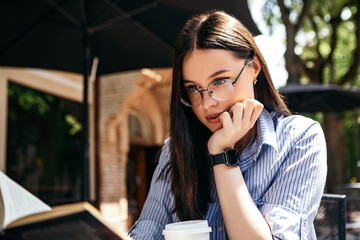 Business woman sitting outside terrace porch cafe drink hot beverage coffee break have lunch reading book smart watch hand wear stylish glasses copyspace. Rush hour, International Coffee Day 