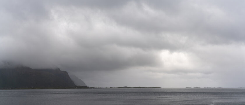 Panorama of a mystical fjord and Atlantic ocean on a cloudy and foggy summer day in the Lofoten Islands of northern Norway