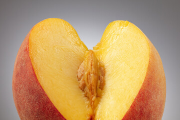 Peach with pulp and pit or kernel. Sliced peach pulp imitating the female sex. Сoncept of sexuality of forms, visual metaphors. Selective focus