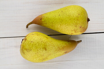 Two juicy ripe pears on a wooden table, close-up, top view.