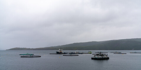 Norwegian fjord with a salmon farm and fishing boats