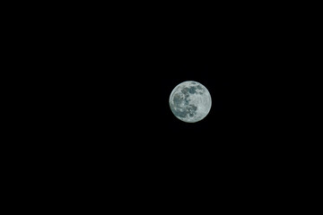 Closeup of full moon. Shining Moon closeup in black background. Soft focus