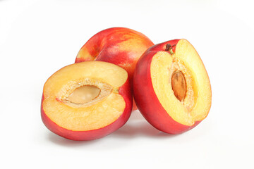 Whole and sliced nectarine with visible seed isolated on white background