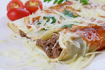 Pancakes with meat, in tomato sauce and cheese, with cilantro and grated cheese on top, and some cherry tomatoes on the plate.