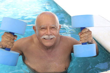 Senior man holding dumbbells in swimming pool