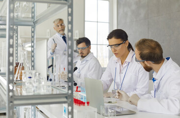 Group of serious male and female scientists, doctors, experts and lab technicians doing medical...